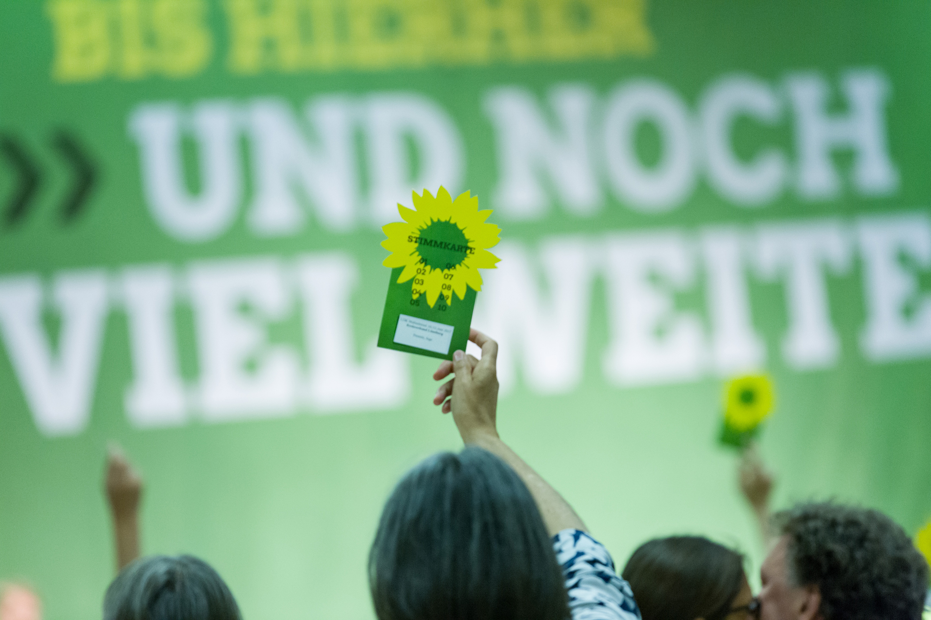 Ein Mitglied hält seine Delegiertenkarte hoch auf einer Landesdelegiertenkonferenz 2017.